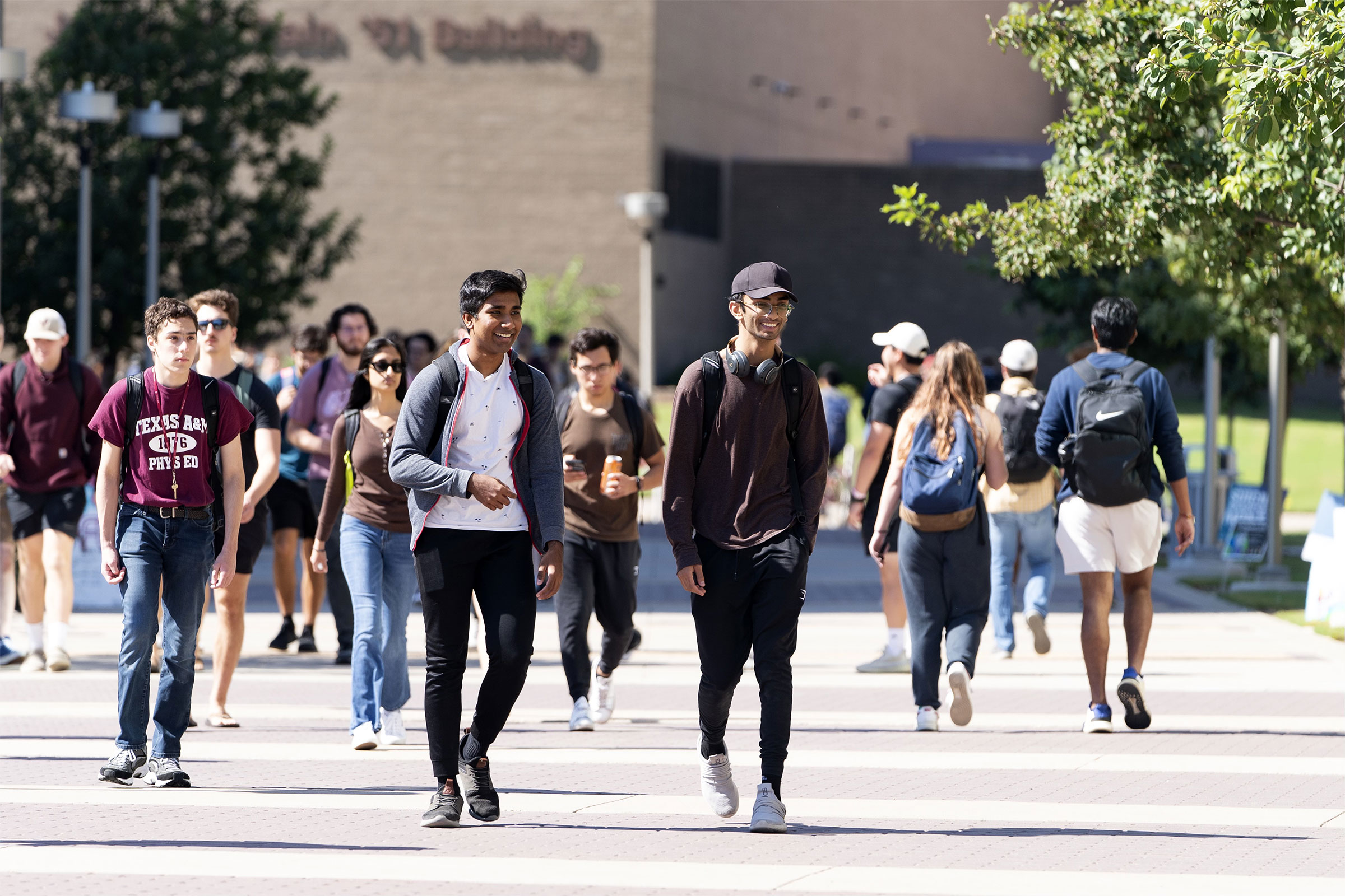 College students walking together on campus on a sunny day.